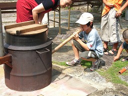 かまどで炊飯する子供たち